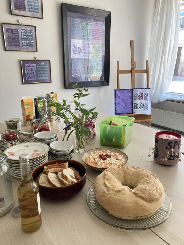 Reichlich gedeckter Tisch für den Kunst-Brunch zur Finissage. Im Hintergrund Arbeiten von Tabea Heinicker.